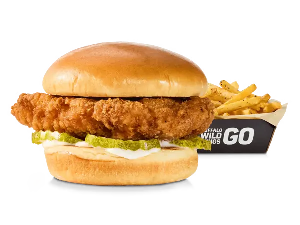 A crispy chicken sandwich coated in sauce, served in a bun with pickles and a side of fries, labeled with 930 calories.