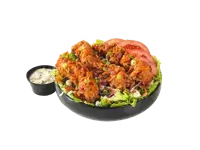 A bowl of crispy hand-breaded chicken served over fresh greens with tomatoes and a side of dressing, priced at $12.99 with 1100 calories.